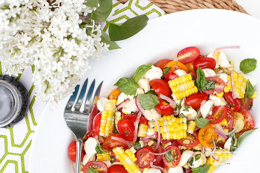 Summers are made for this "ready for entertaining" salad. Vine ripe tomatoes, grilled corn, sweet basil, a hint of lemon zest and healthy drizzle of EVOO. Perfect for your next grill out, garden party or summer potluck. Summer Tomato Salad with Grilled Corn, Mozzarella, and Basil recipe at www.designsofanykind.com