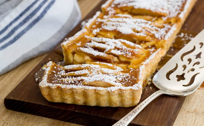 Celebrate the fall season with this mouthwatering Caramel Apple Tart with a Cornmeal Cheddar Crust. The flavors are absolutely divine! Recipe at www.designsofanykind.com
