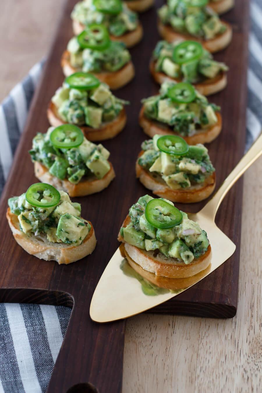 Delicious bruschetta topped with an aromatic mixture of avocados, herbs, garlic, and jalapenos. They are easy to make and perfect for a snack, appetizer, or tapas dinner. Recipe at www.designsofanykind.com