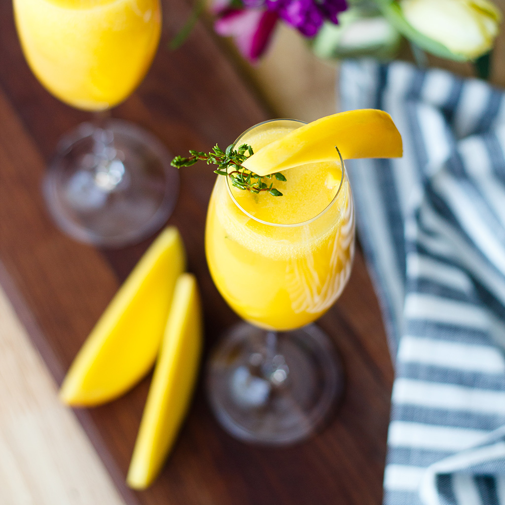Pop open a bottle of champagne and celebrate with these mango thyme mimosas that are as beautiful as they are delicious! Recipe at www.designsofanykind.com