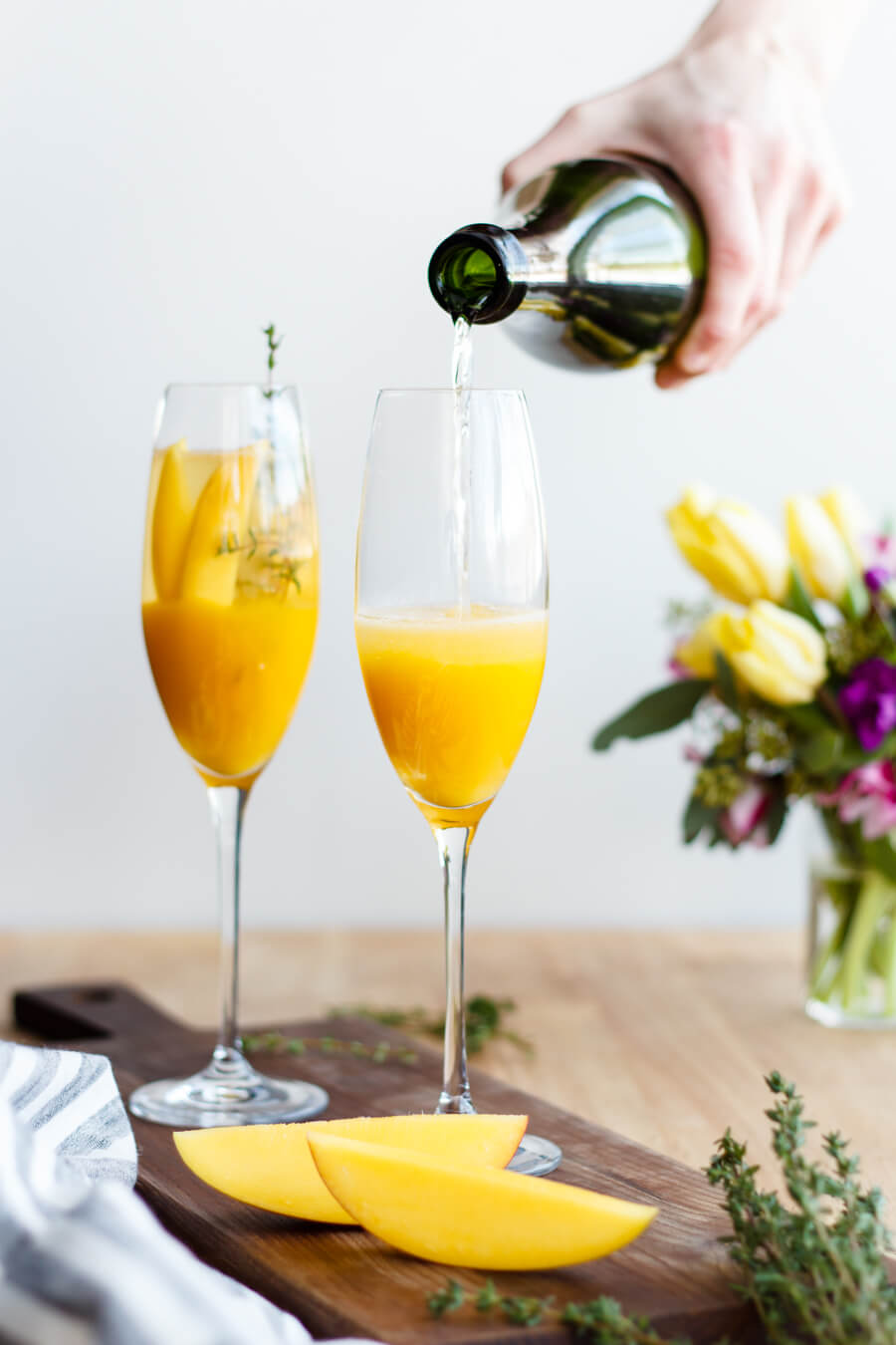 Pop open a bottle of champagne and celebrate the spring season with these mango thyme mimosas that are as beautiful as they are delicious! Recipe at www.designsofanykind.com
