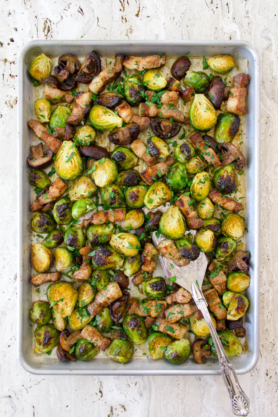 These Roasted Brussel Sprouts with Pork Belly & Mushrooms are super easy to make and roast in one pan for a very delicious side dish! Recipe at www.designsofanykind.com