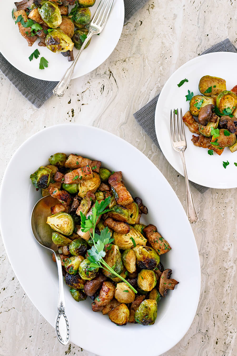 These Roasted Brussels Sprouts with Pork Belly & Mushrooms are super easy to make and roasted all in one pan for a very delicious side dish! Recipe at www.designsofanykind.com