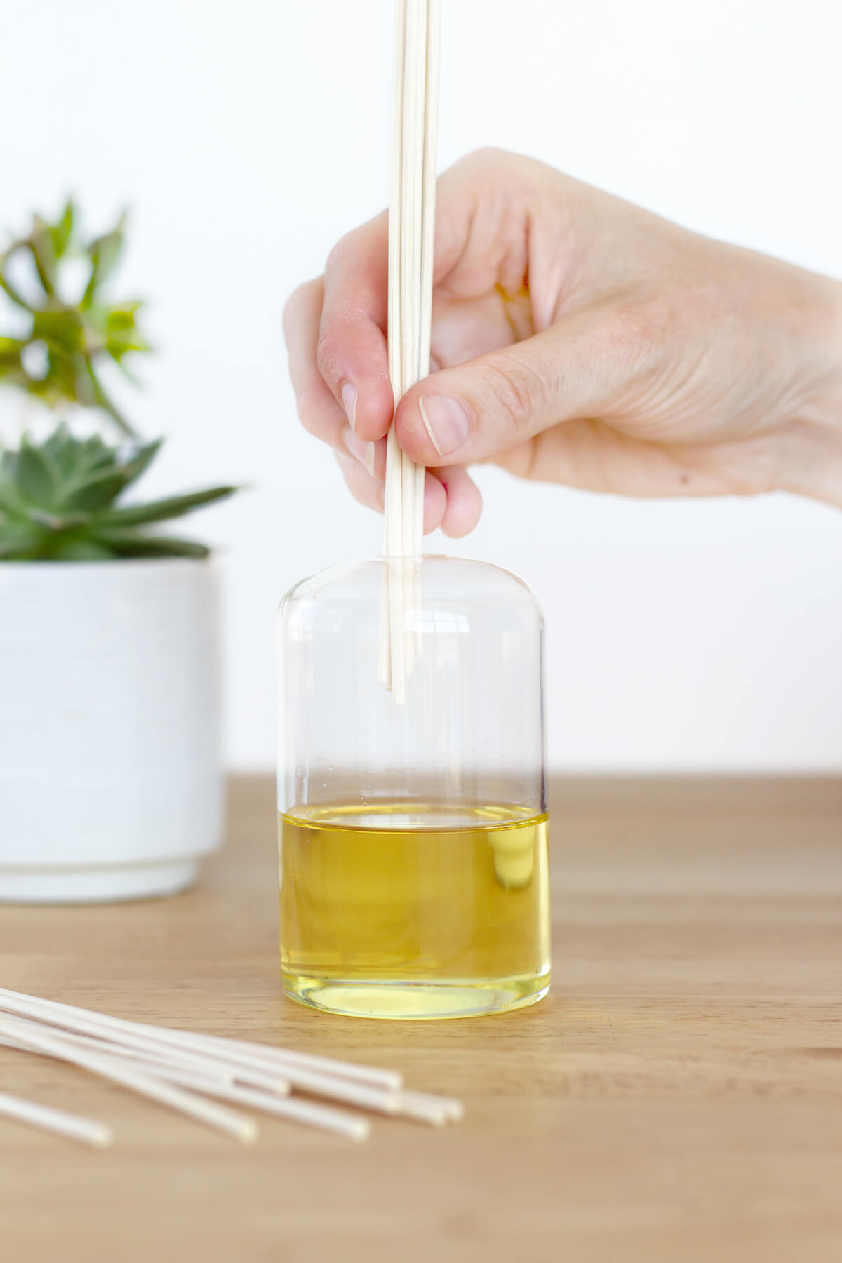 Learn how to make your own reed diffuser using essential oils. They are easy to make + cost a fraction of the price of diffusers sold in high-end retailers. Get this DIY and other great projects or delicious recipes at www.designsofanykind.com