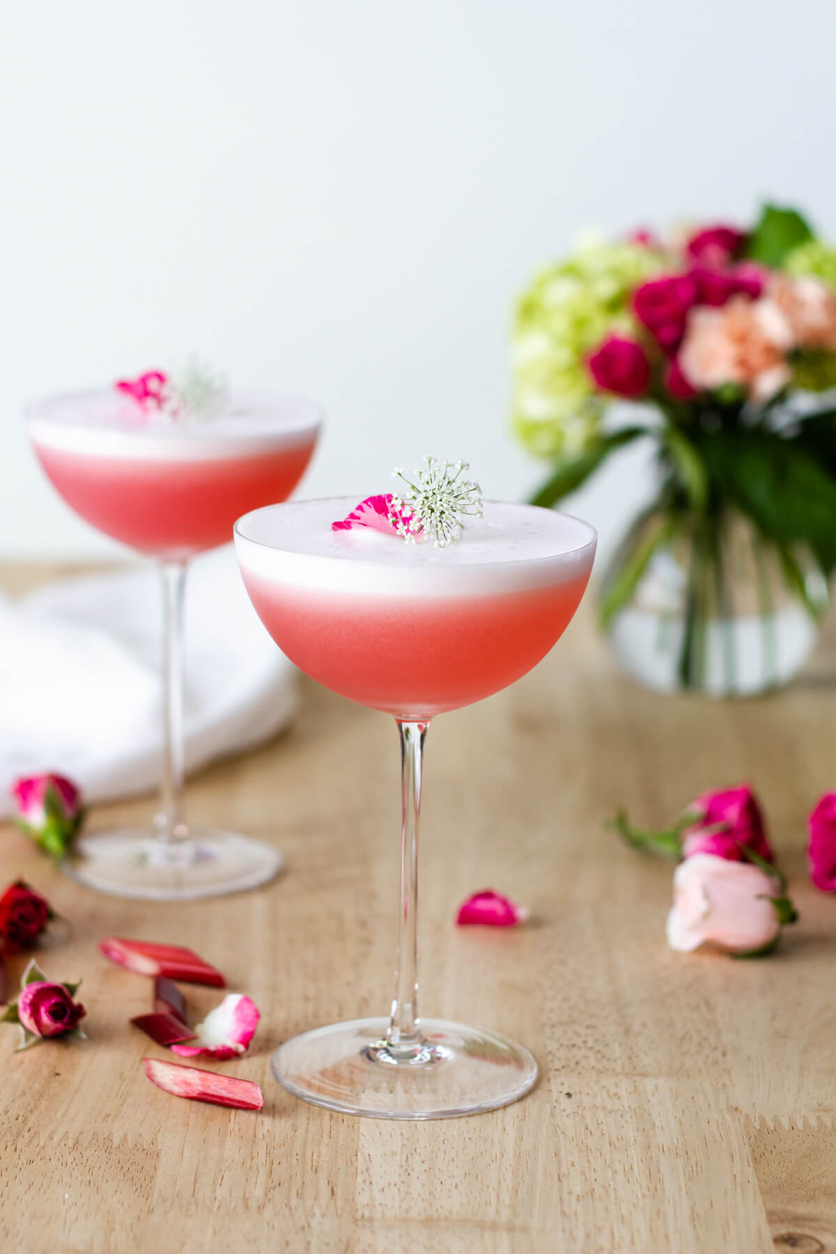 The Rhubarb Rose Gin Sour makes for a refreshingly beautiful cocktail. This is a fun way to use up all of those rhubarb plants growing in your garden. Cocktail recipe at www.designsofanykind.com